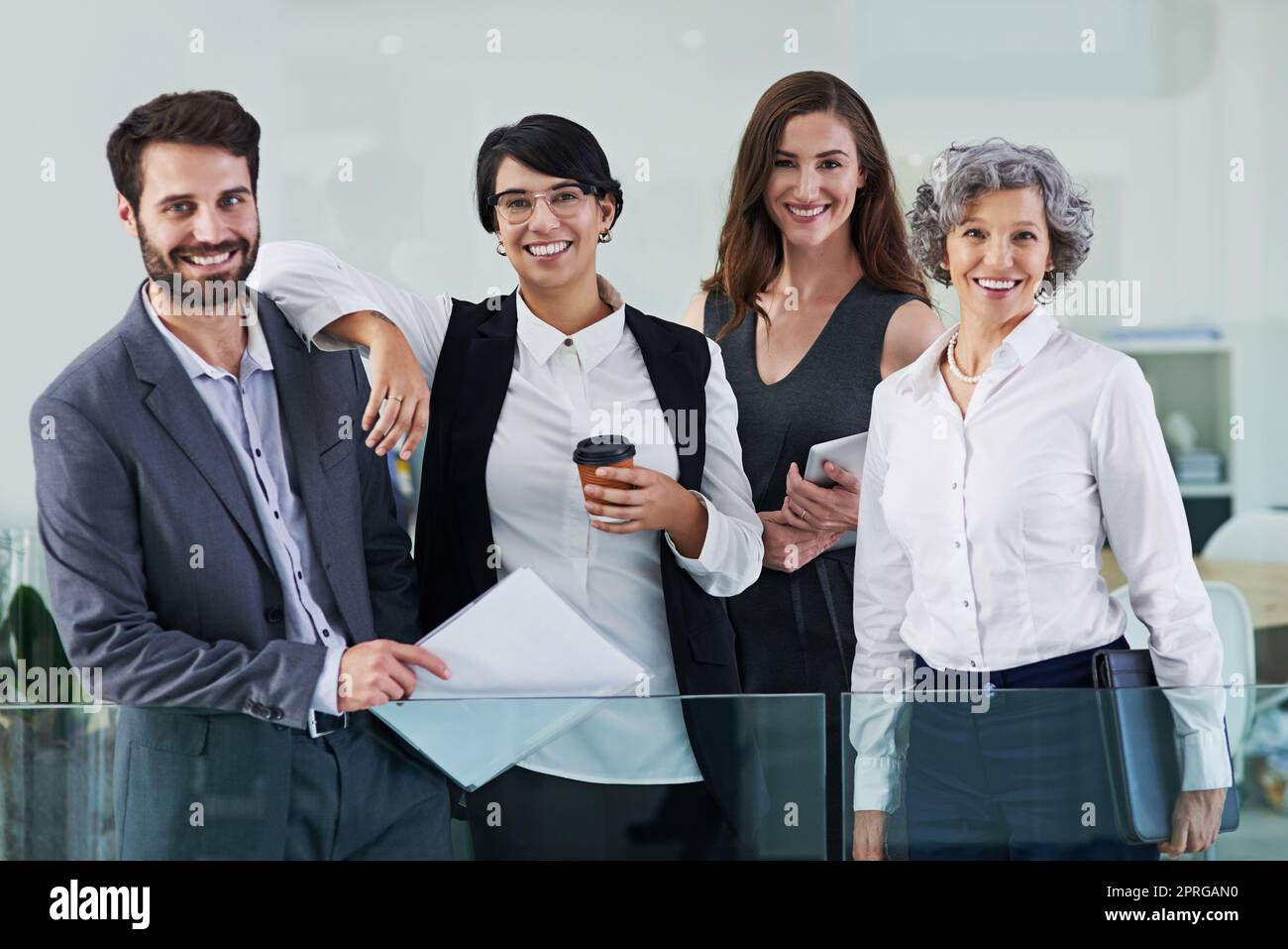 Were all about conquering challenges. Portrait of a group of businesspeople standing together in a modern office. Stock Photo