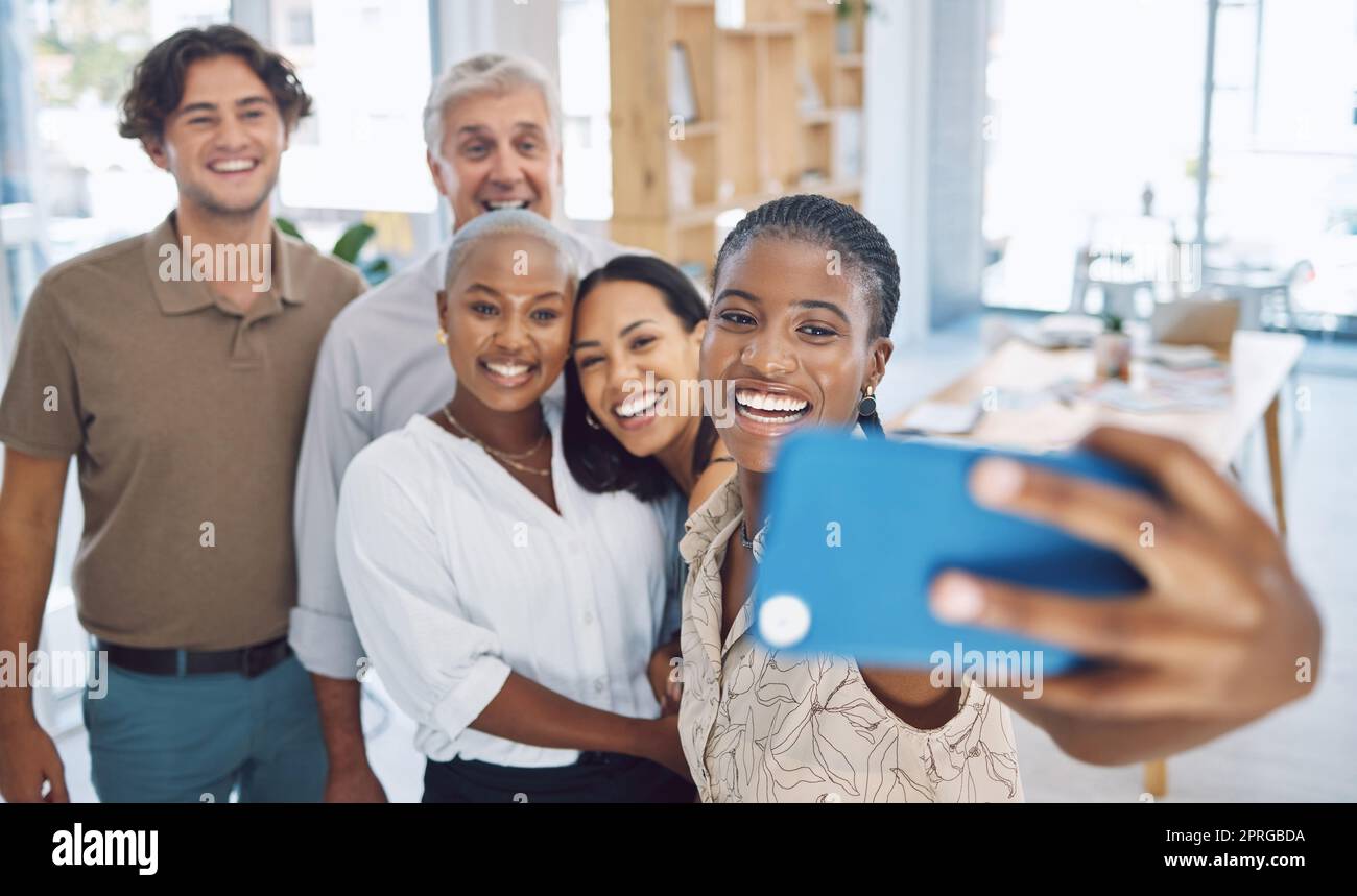 Phone, selfie and teamwork with a business team working in collaboration in their office and taking a picture. Motivation, diversity and photograph with happy friends having fun together at work Stock Photo
