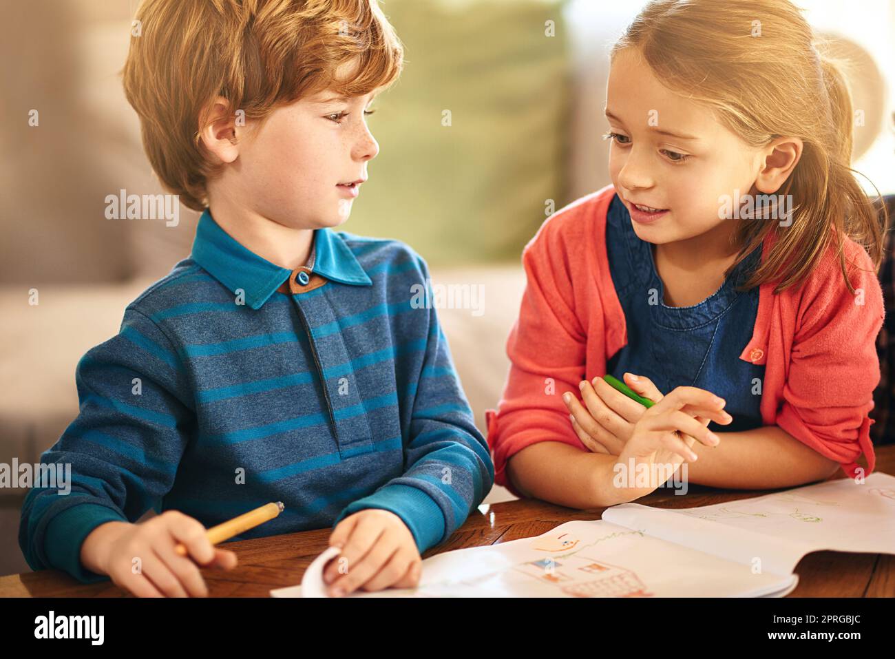 Colouring fun with little sister. a brother and sister colouring in together. Stock Photo