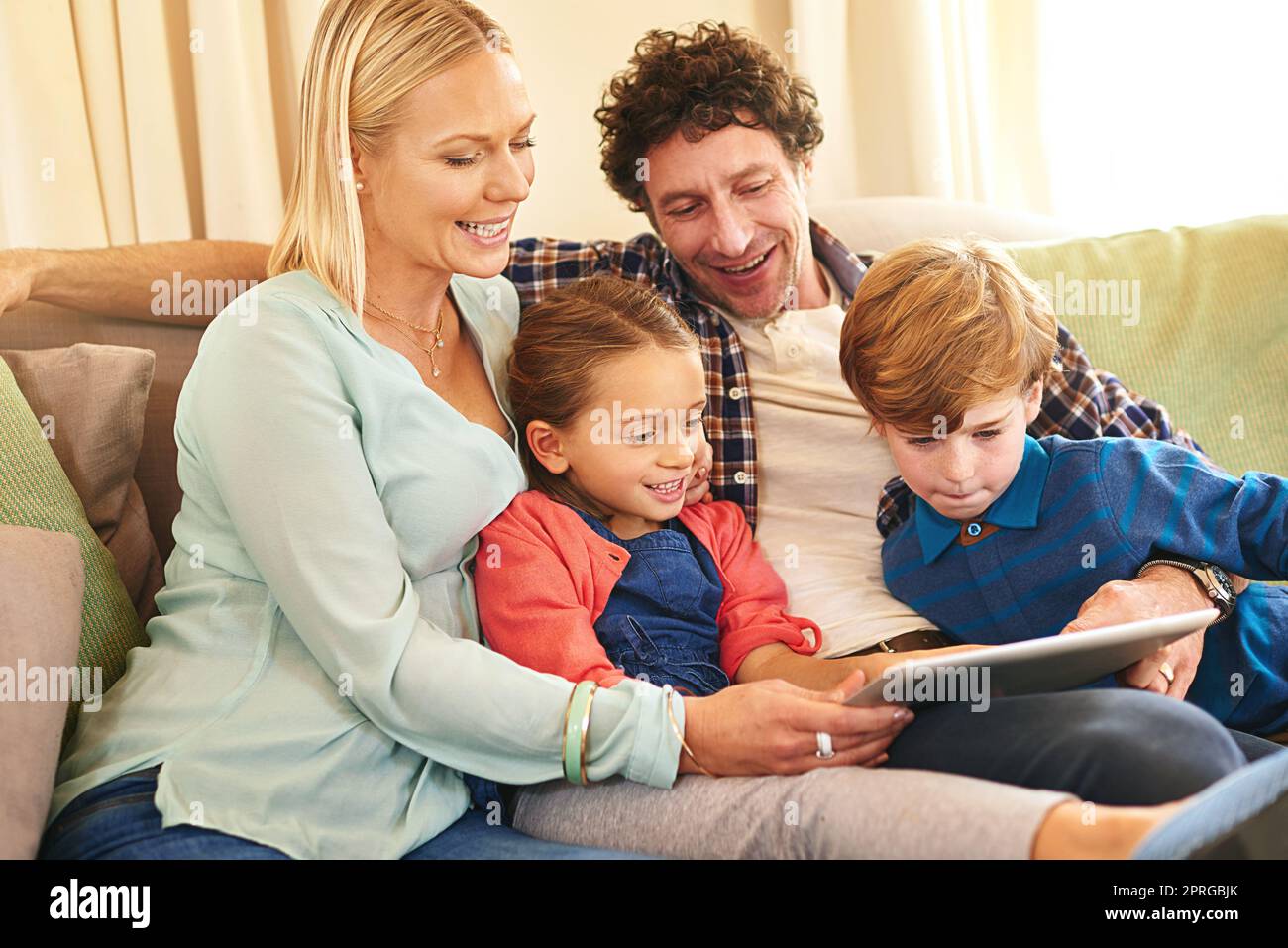 Weekend entertainment gone digital. a family browsing together on a digital tablet at home. Stock Photo