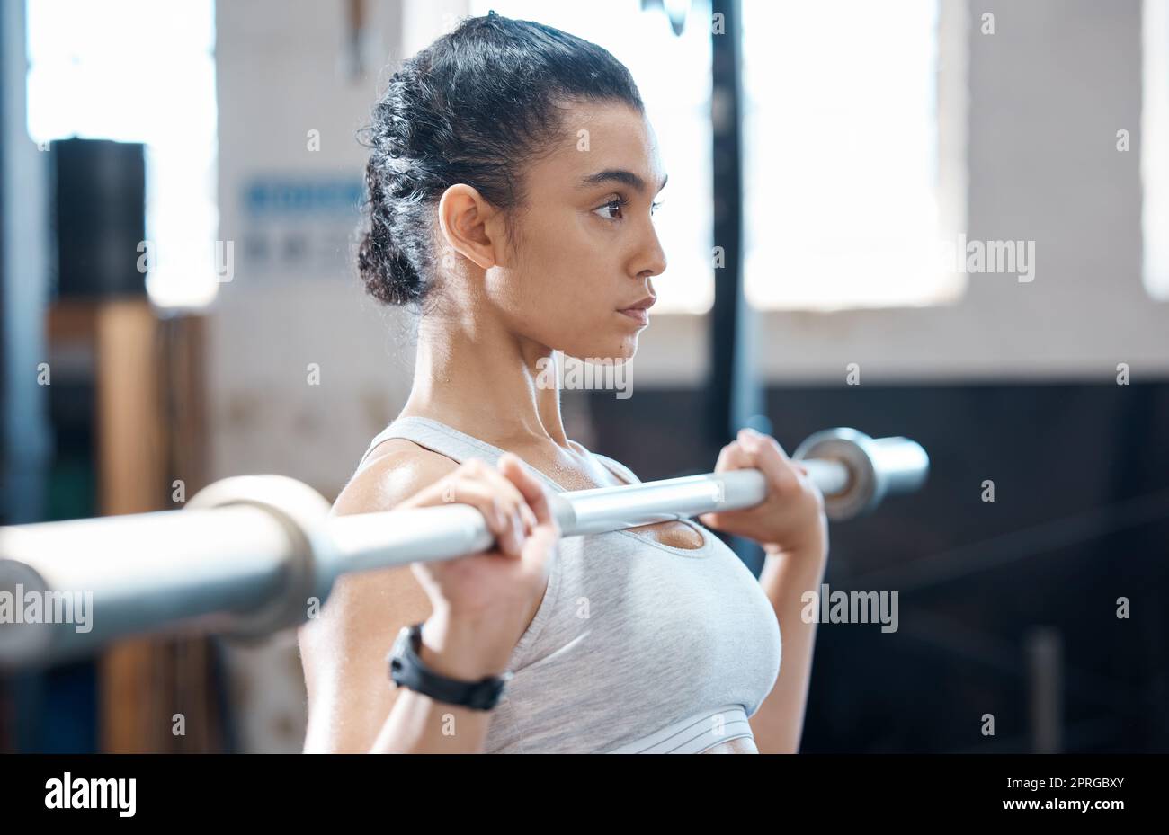 Weight lifting, woman fitness and exercise workout of a bodybuilder with sports motivation and focus. Sport and strength training of a Mexican athlete working out in a wellness, health and gym studio Stock Photo