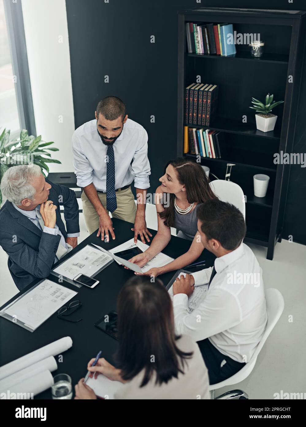 Discussing the way forward. High angle shot of a group of businesspeople meeting in the boardroom. Stock Photo