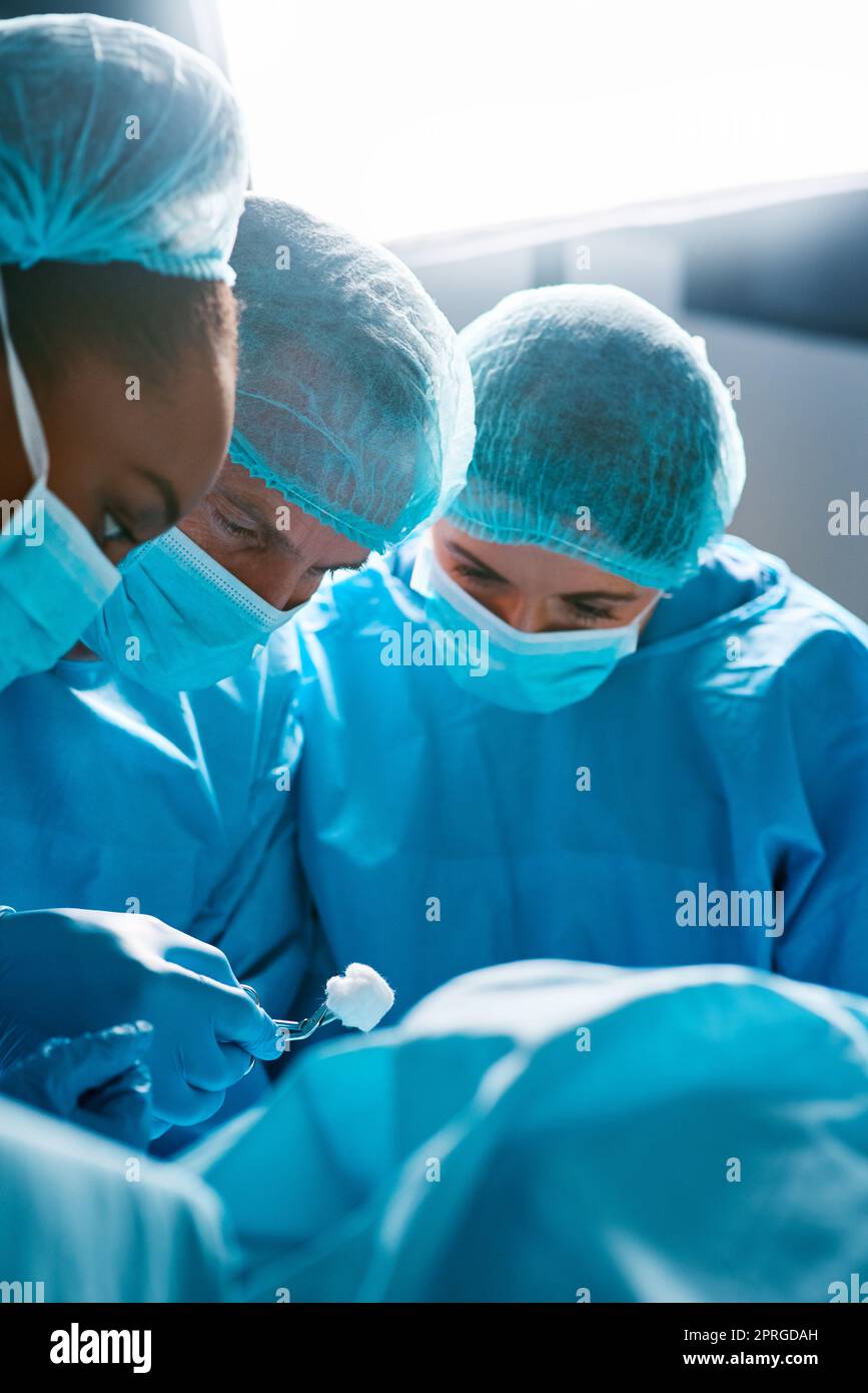 Steady hands and a strong dedication. a group of surgeons operating on