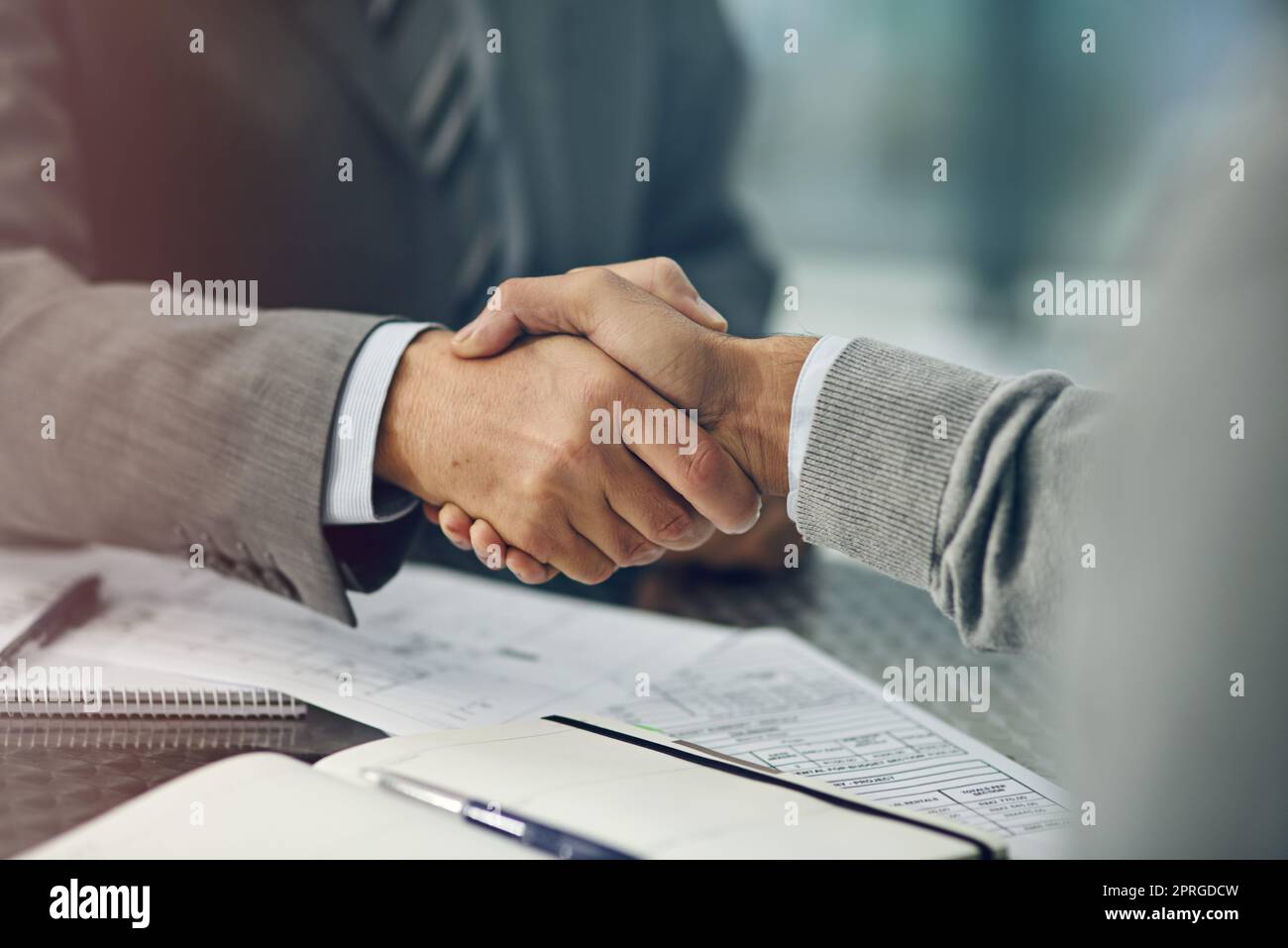 Theyve reached an agreement. two unrecognizable businessmen shaking hands in an office. Stock Photo