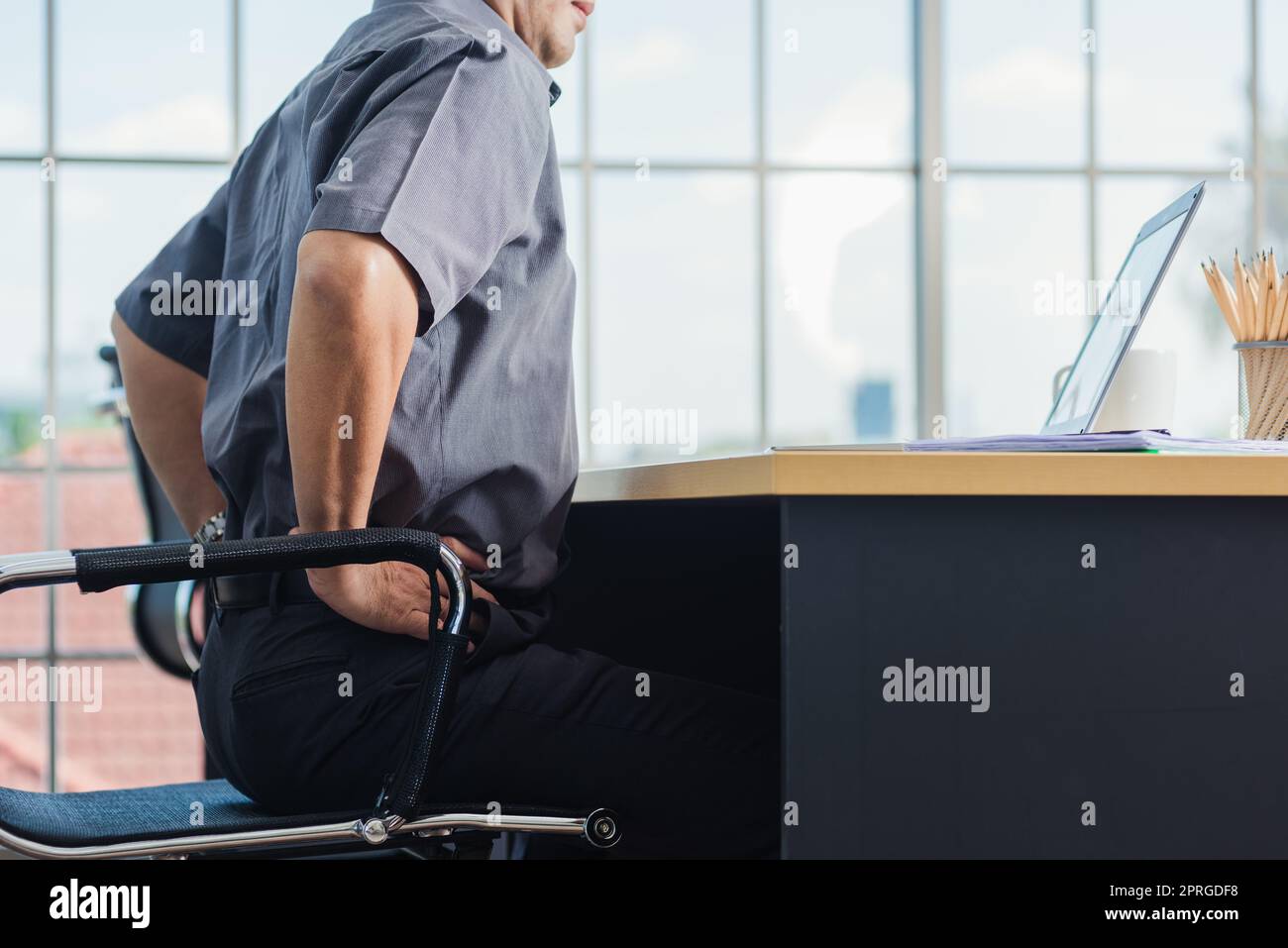 senior businessman working with laptop computer has a problem with back pain Stock Photo