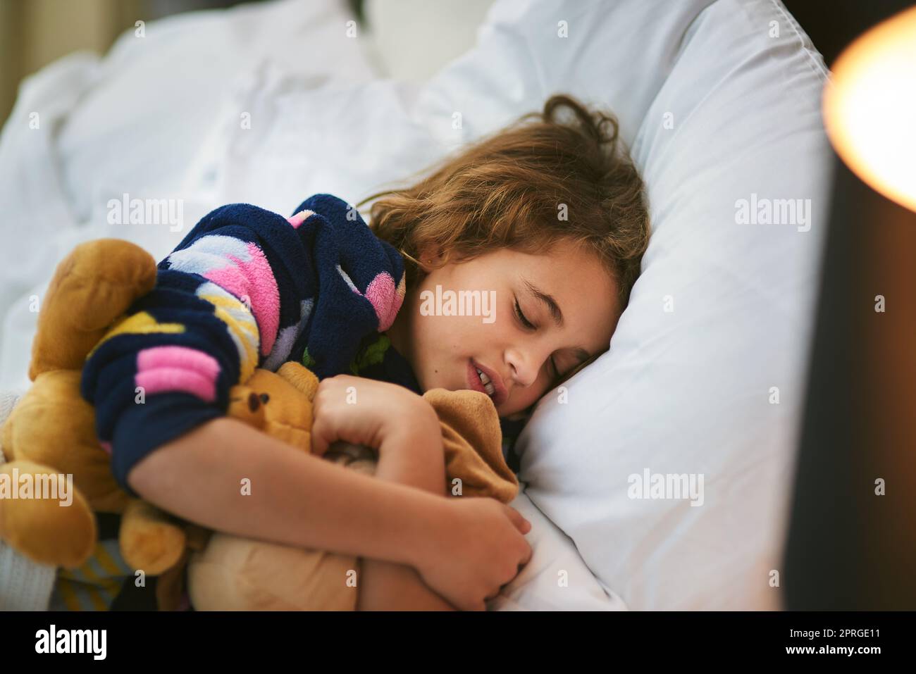Naptime companions. a young girl sleeping with soft toys. Stock Photo