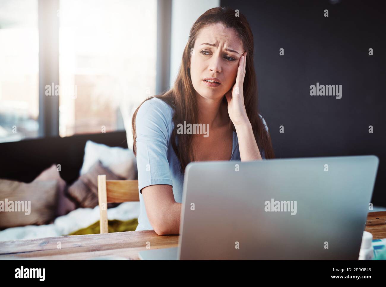 She cant afford anymore sick days. a young businesswoman trying to work while suffering with the flu. Stock Photo