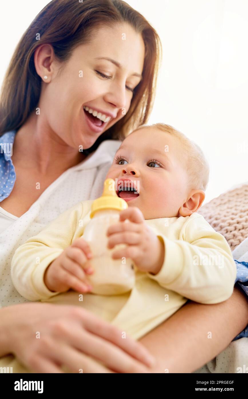 Babies bring so much joy into our lives. a baby drinking his bottle while lying in his mothers arms. Stock Photo