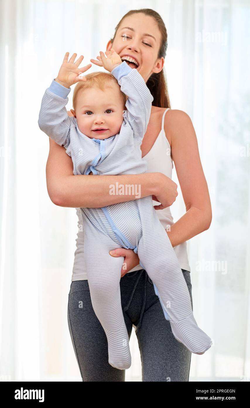 And then you stretch...a young woman working out while spending time with her baby boy. Stock Photo