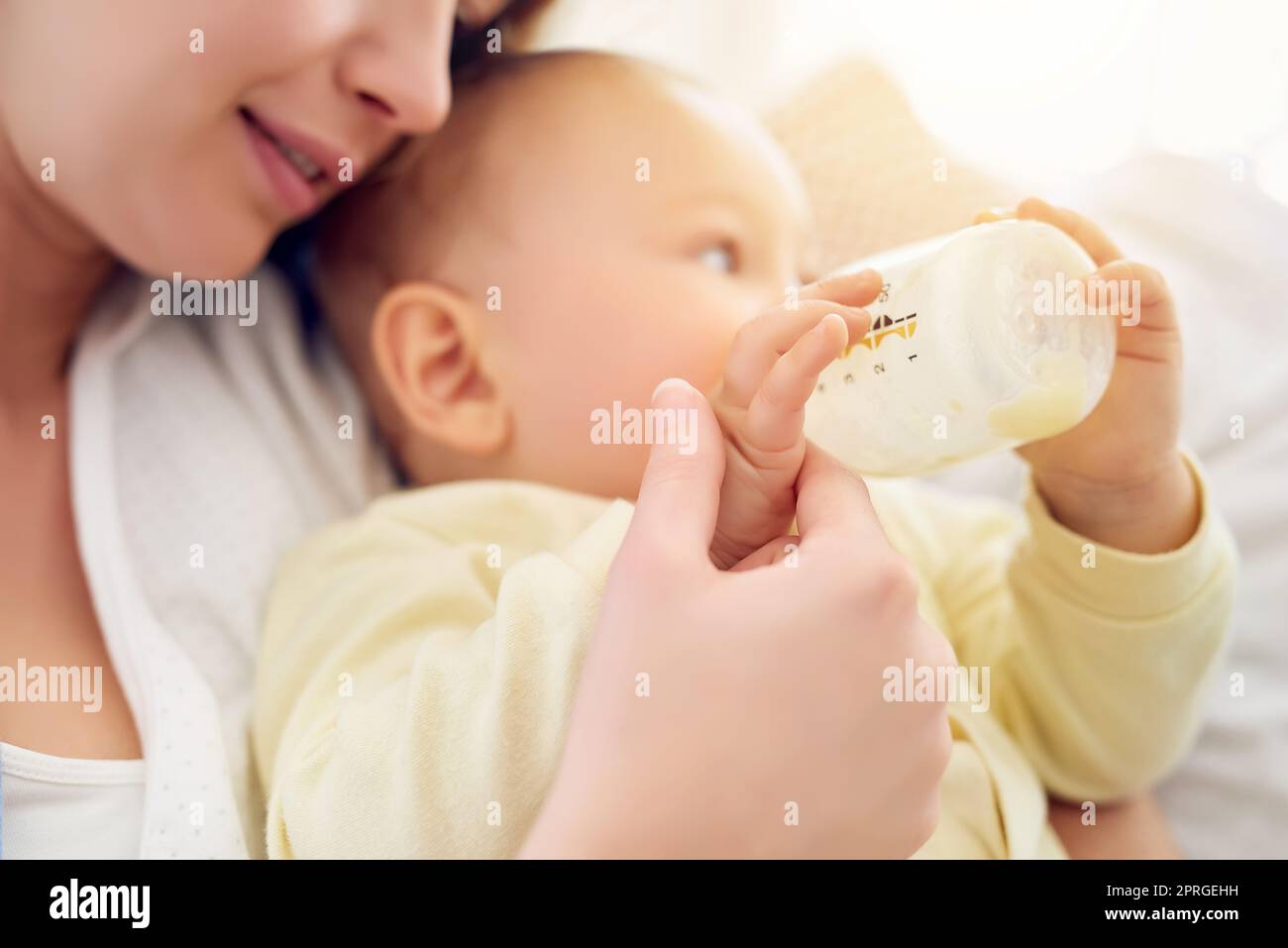 Hes my definition of perfect. a baby drinking his bottle while lying in
