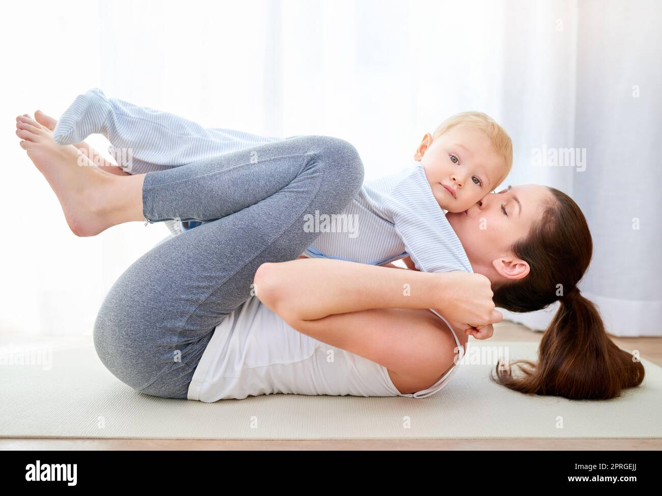 Not the lips mom. a young woman working out while spending time with her baby boy. Stock Photo
