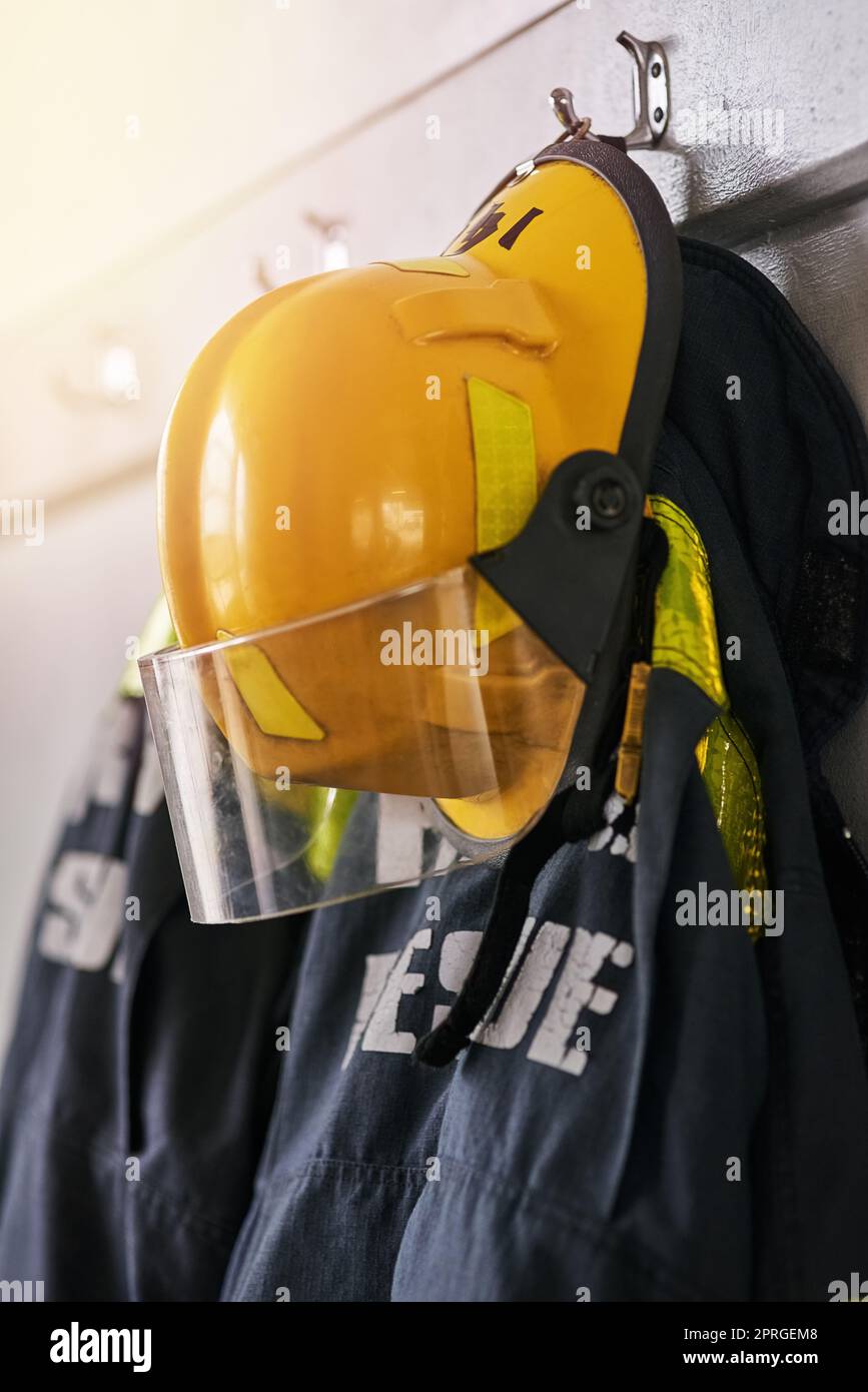 Safety first. firemens clothing hanging from a wall. Stock Photo