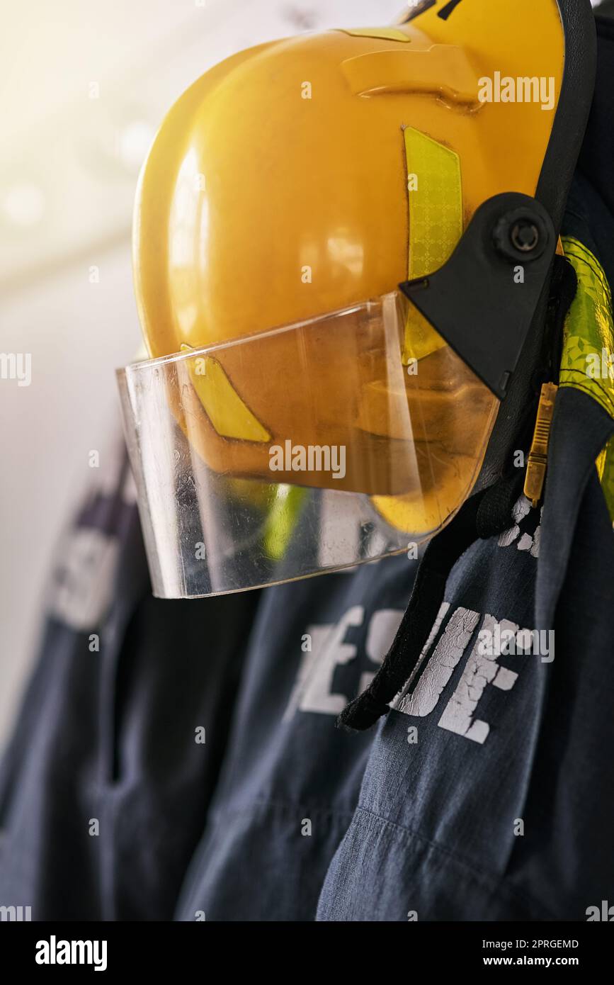 Fire fighting gear. firemens clothing hanging from a wall. Stock Photo