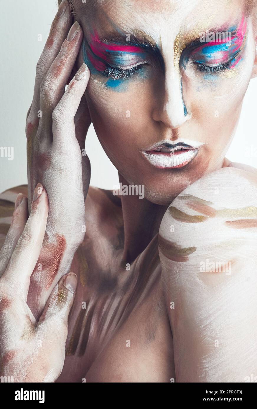 Dreaming in colour. Studio shot of a young woman posing with paint on her face. Stock Photo
