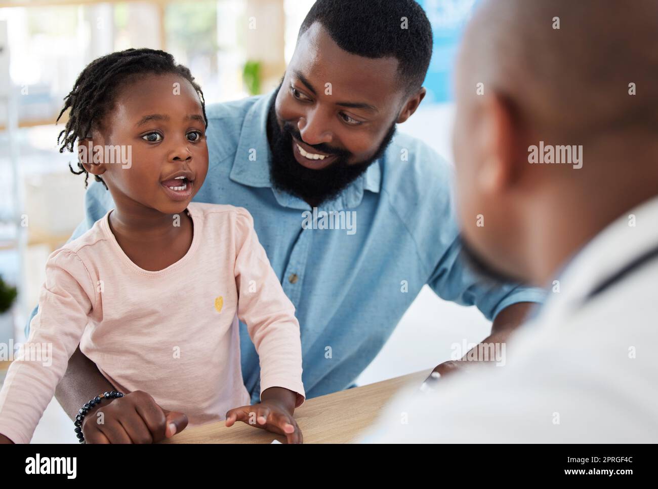 Kids doctor, black family and consulting hospital worker in medical, insurance or healthcare help. Girl, happy father and pediatric employee in conversation or communication in children wellness room Stock Photo