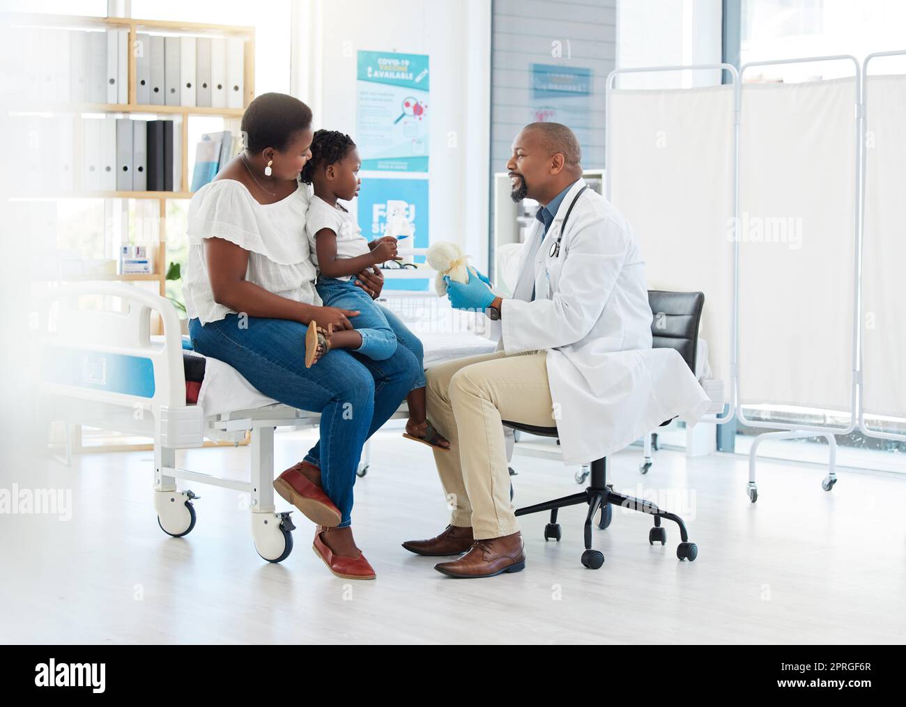 Doctor, nurse or medical worker consulting with baby, mother and child patient for flu, allergies or covid in hospital room. Medicine, trust and support in a medical clinic with a health professional Stock Photo
