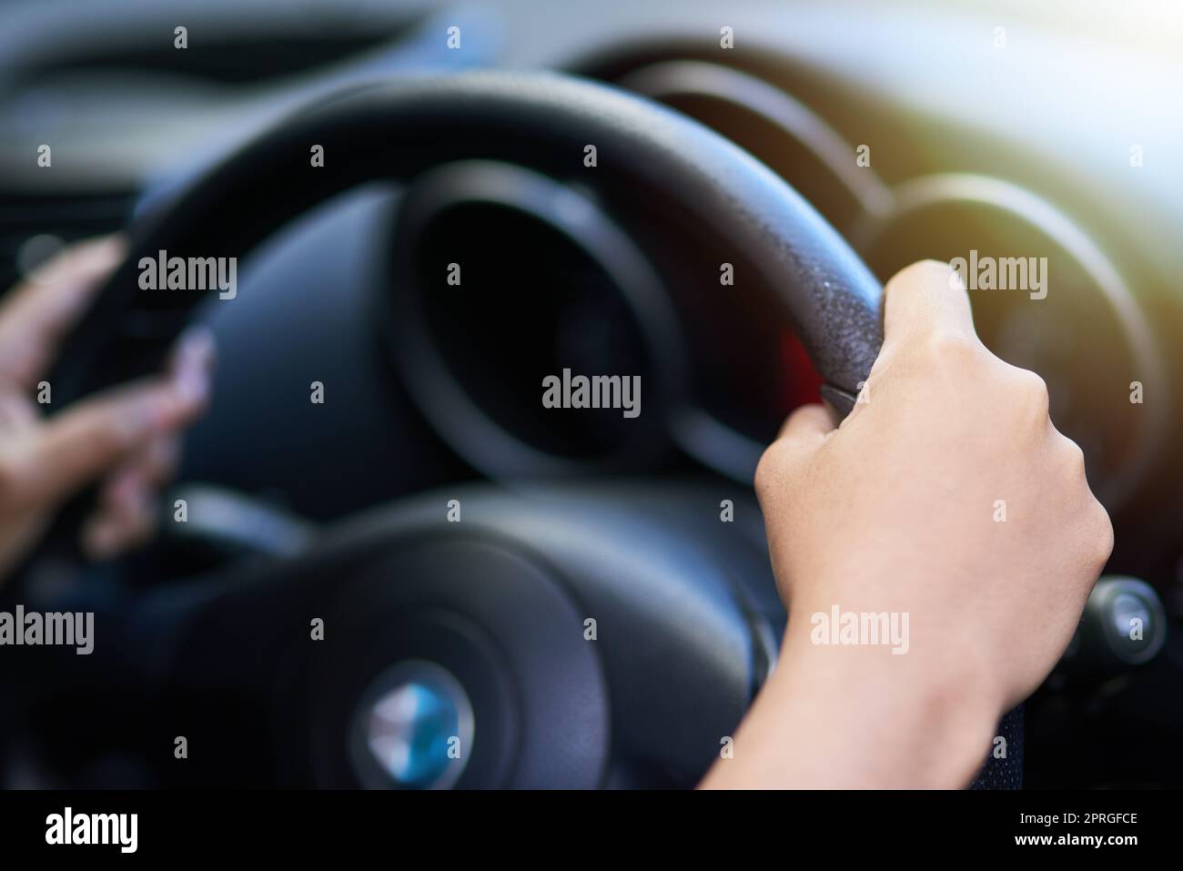 Drive safely and carefully. hands holding onto a steering wheel while driving. Stock Photo