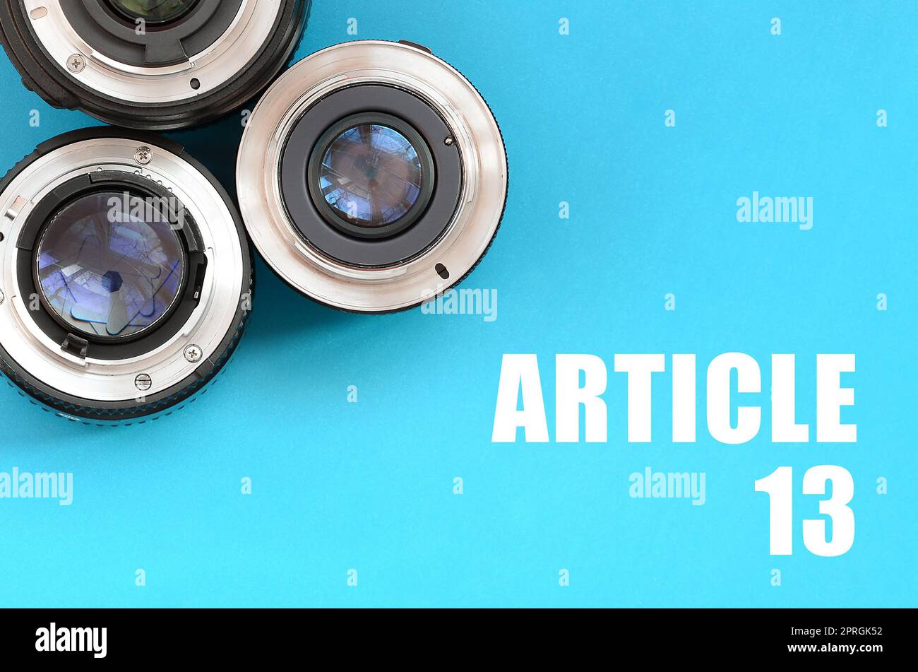 Several photographic lenses and article 13 inscription on blue background. European copyright directive including article 13 is approved by european p Stock Photo