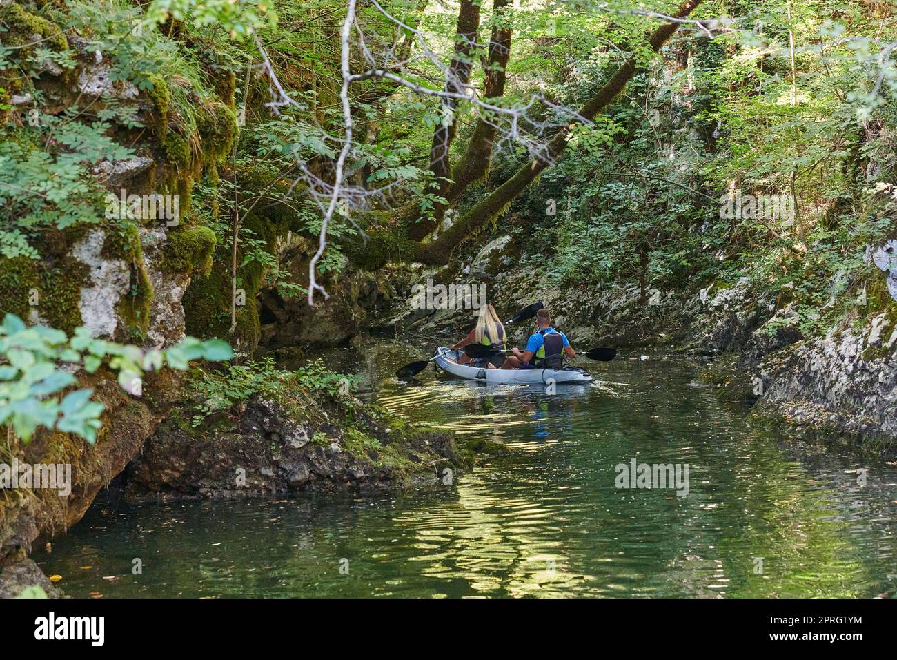 A young couple enjoying an idyllic kayak ride in the middle of a ...