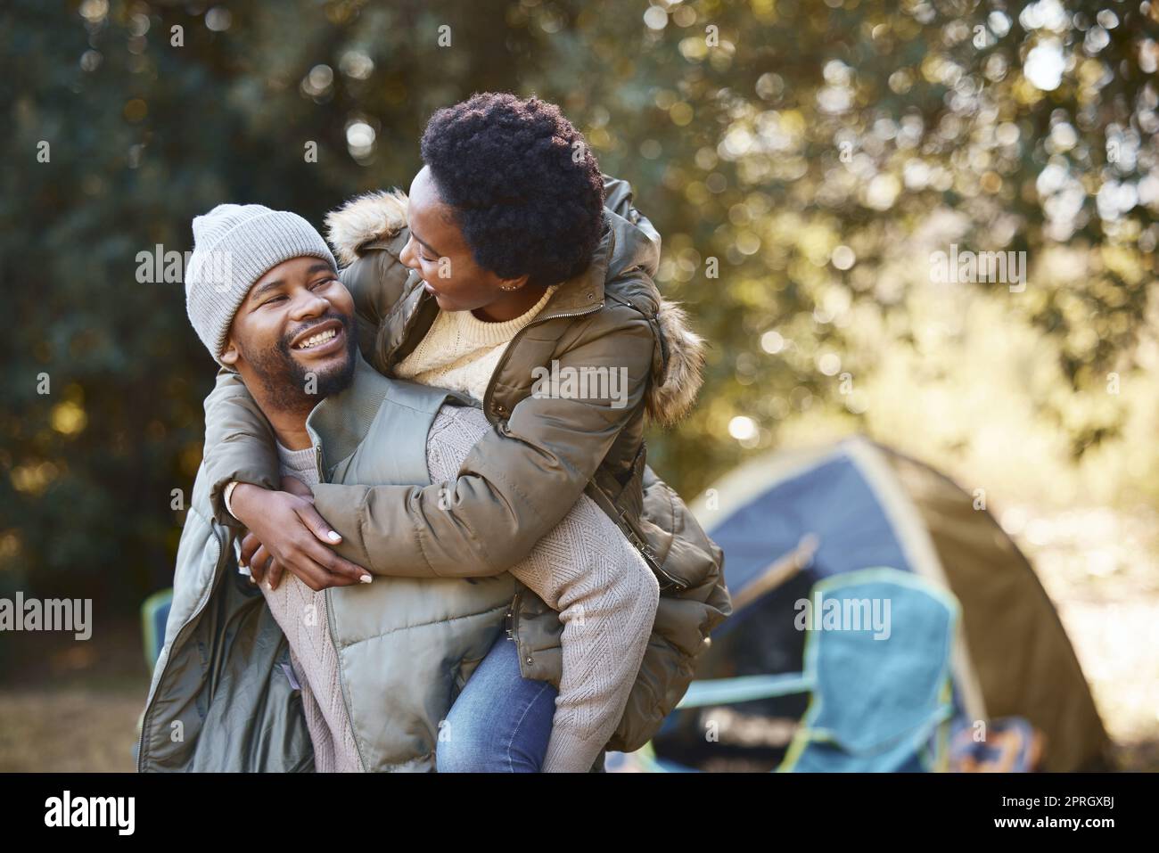 Youve been getting to strong lately. a young man giving his wife a  piggyback ride while camping Stock Photo - Alamy