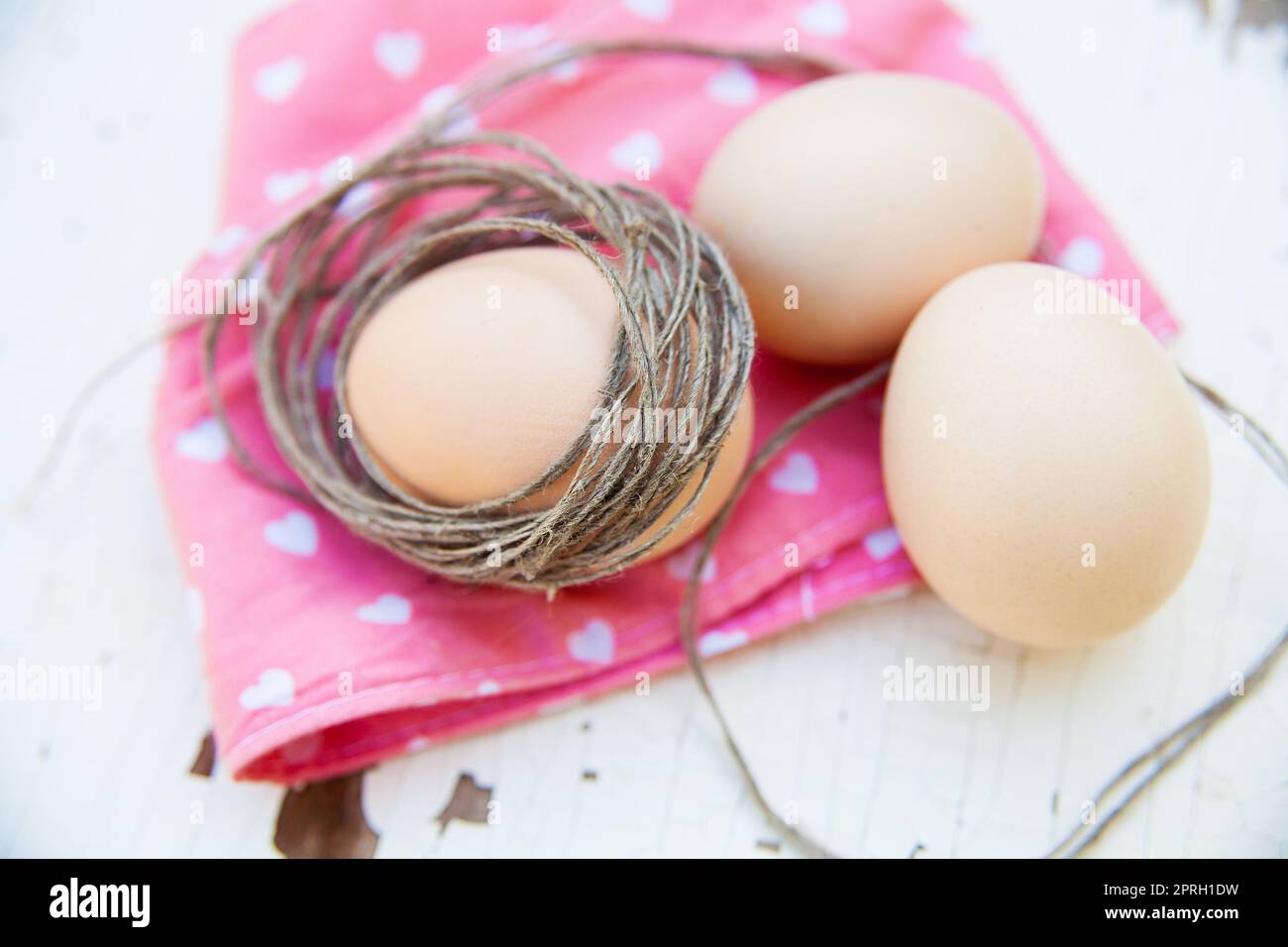 three eggs on the table on a rose napkin. Stock Photo