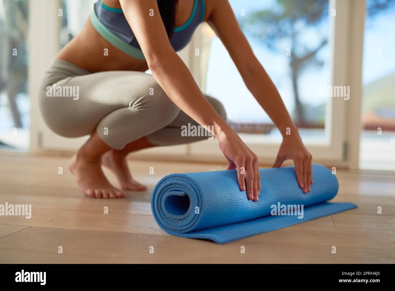 Roll out fatigue and roll in fitness. an unidentifiable woman rolling a yoga mat. Stock Photo