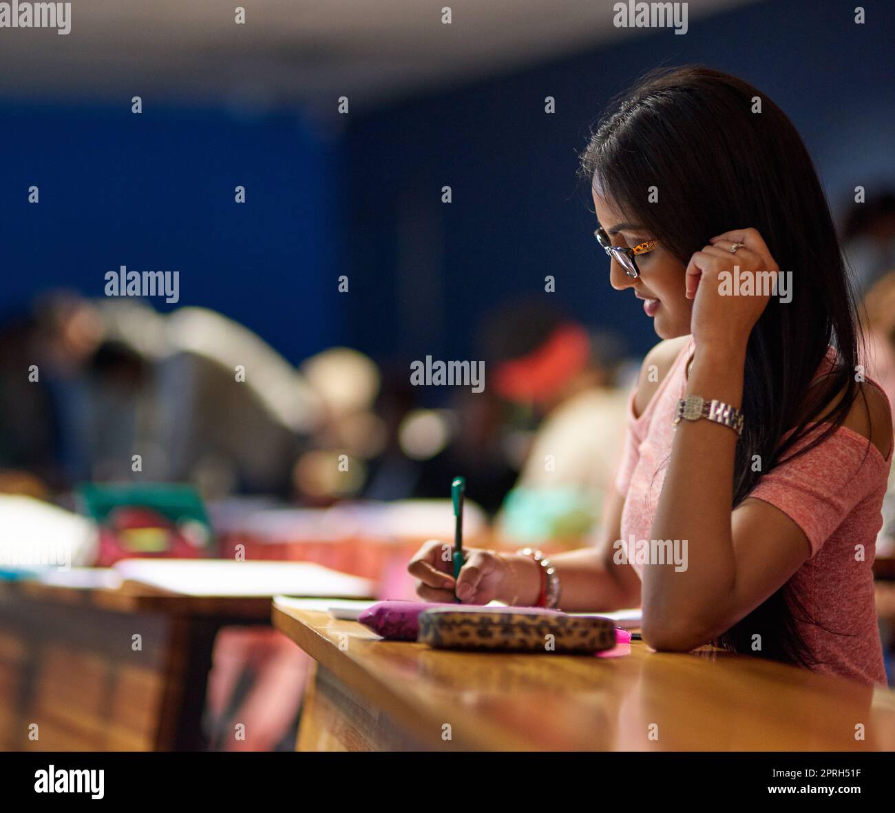 What the mind forgets, the page remembers. a beautiful university student making notes while sitting in a lecture hall. Stock Photo