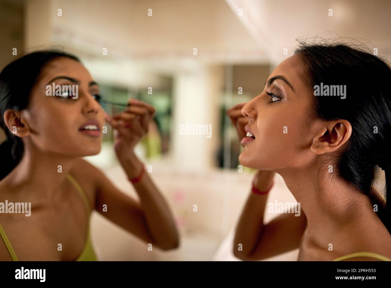 Enhancing her big beautiful eyes. a young woman applying mascara in the bathroom. Stock Photo