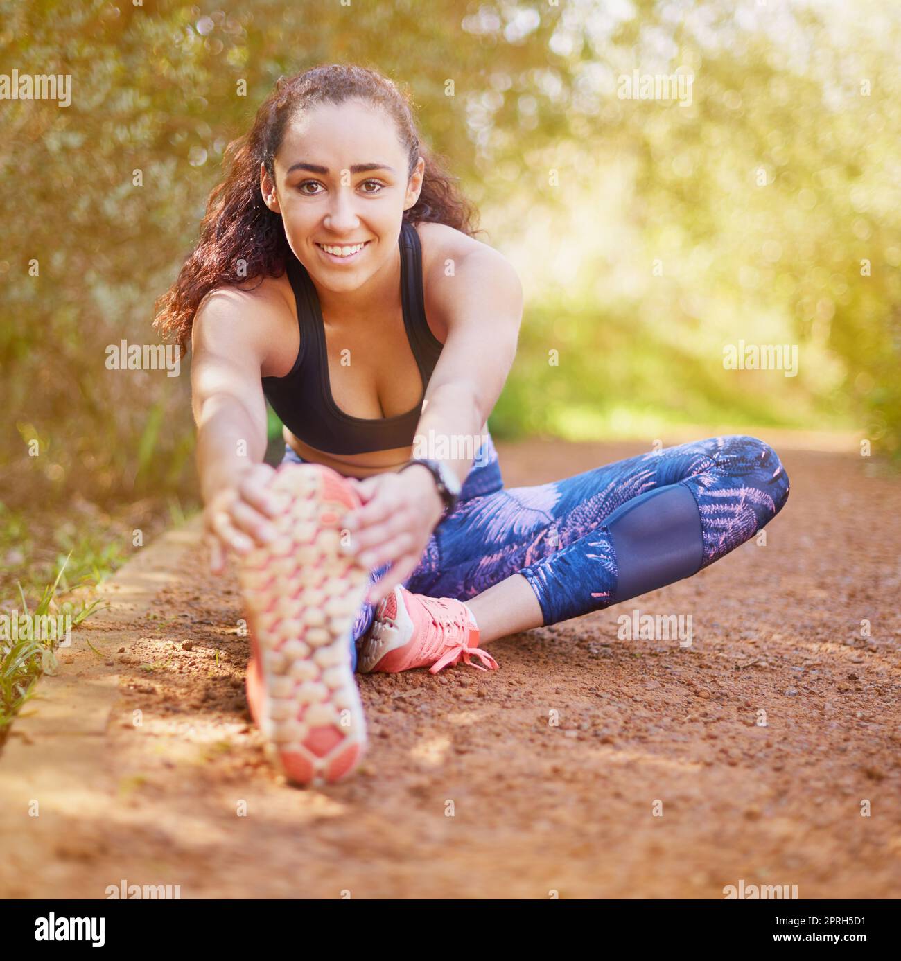 Incorporate a warm-up series before your work out. a sporty young woman stretching before her run. Stock Photo