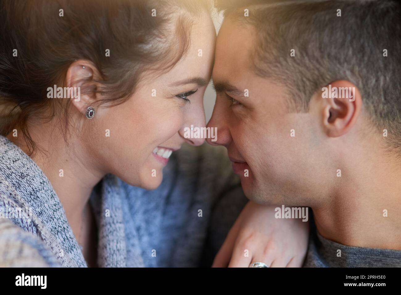 Its you and me babe. an affectionate young couple sitting face to face on the sofa at home. Stock Photo