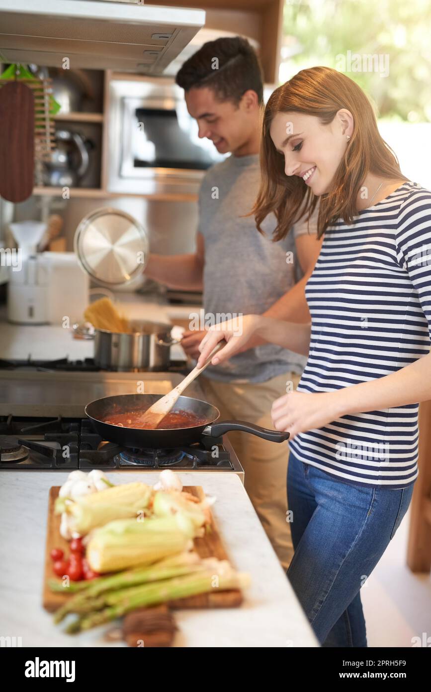 Dinner done our way. a happy young couple cooking a meal together in their kitchen. Stock Photo