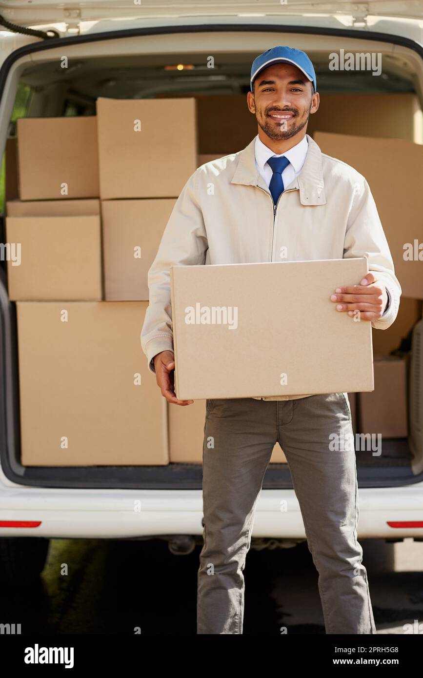 Getting it right and on time. Portrait of a friendly delivery man unloading cardboard boxes from his van. Stock Photo