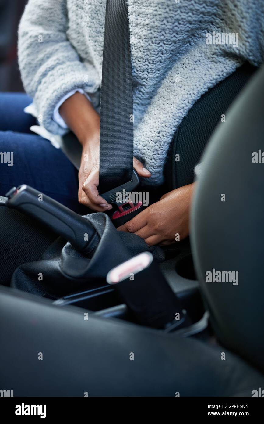 Safety comes first. Closeup shot of a woman fastening her seatbelt in a car. Stock Photo