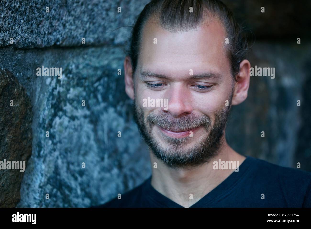 Being himself. Portrait of a man leaning against a wall outside. Stock Photo