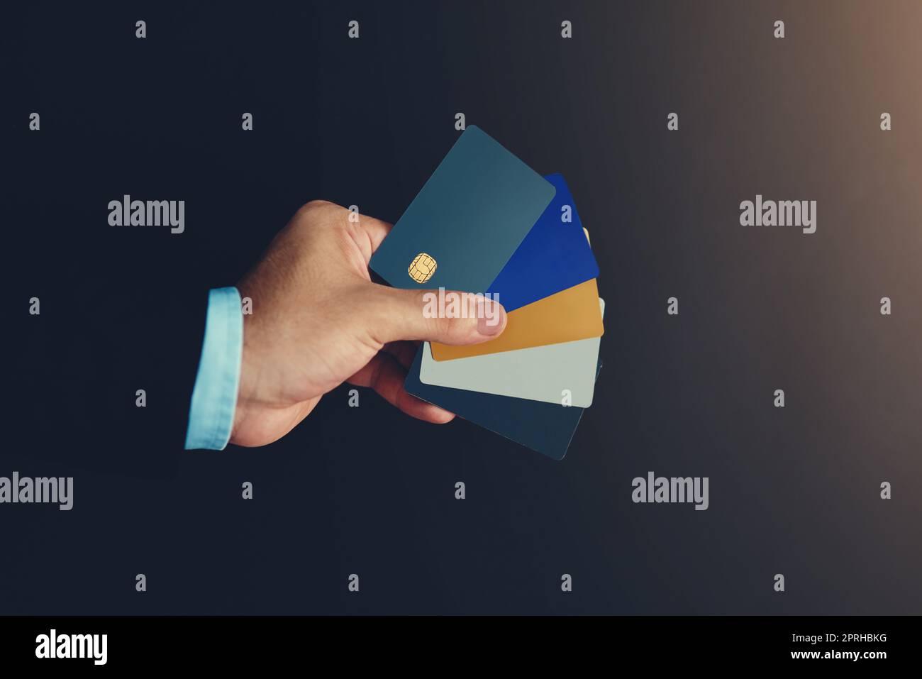 Settle the charge by card. Studio shot of an unidentifiable businessman holding a selection of credit cards against a black background. Stock Photo