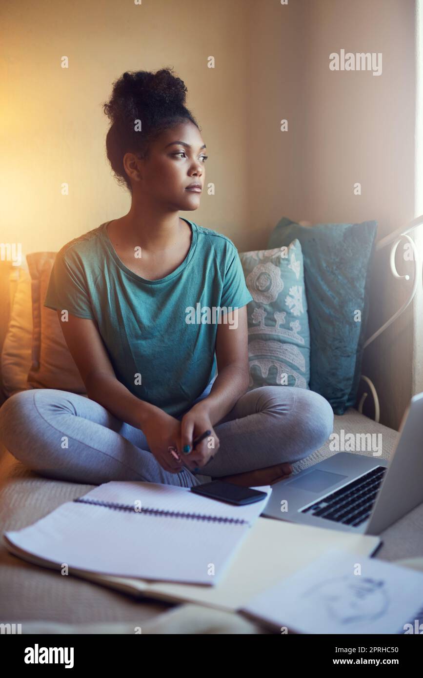 Wrapping her head around all the content. Full length shot of a young female student studying at home. Stock Photo
