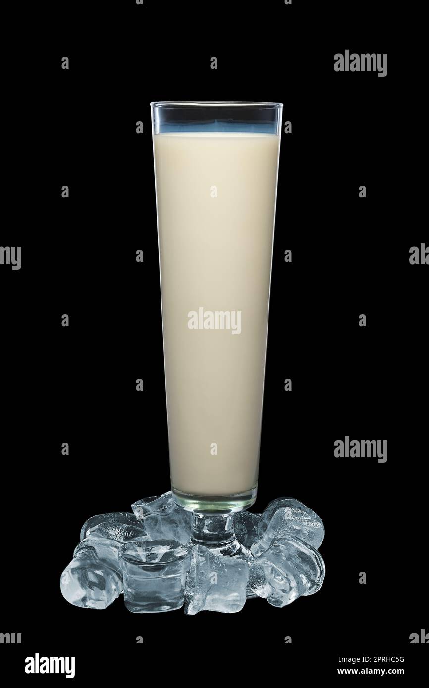 Tall glass of milk surrounded with ice cubes isolated on black