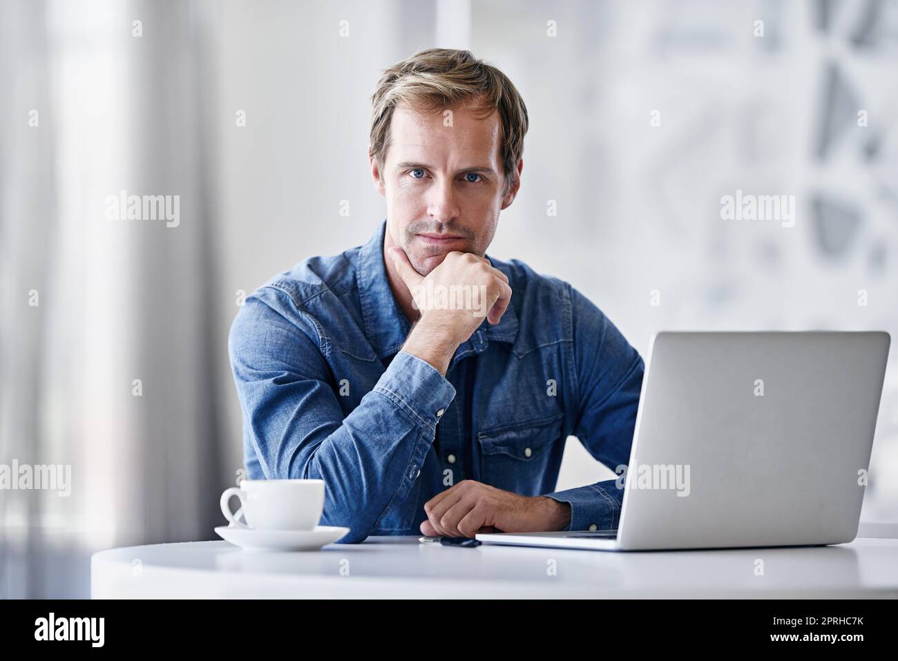 His success is based on his actions. Portrait of a mature businessman using a laptop while sitting at a desk in an office. Stock Photo