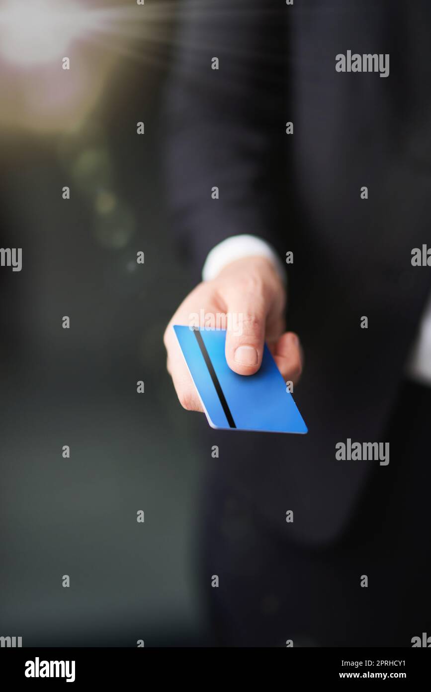 Managing his finances. a businessman holding out a credit card. Stock Photo