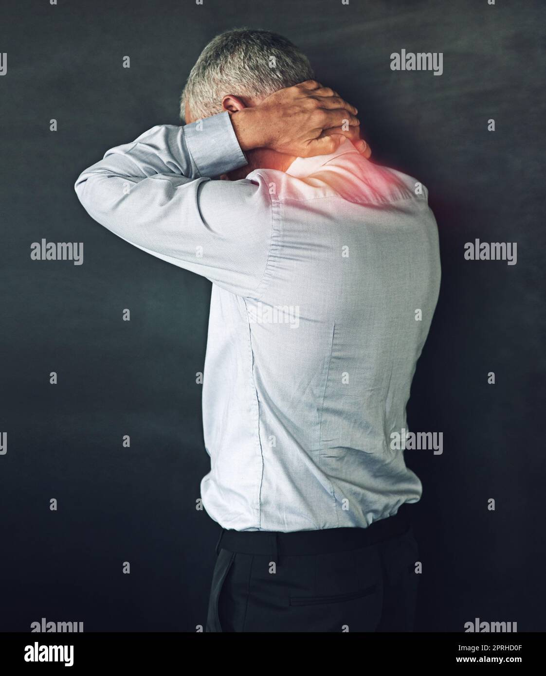 When pain strikes. Studio shot of a mature man experiencing neck ache against a black background. Stock Photo