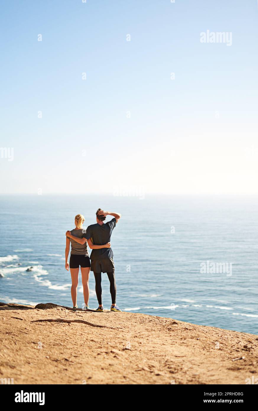 There are no shortcuts to any place worth going. a young couple looking at the view from the top of a mountain. Stock Photo