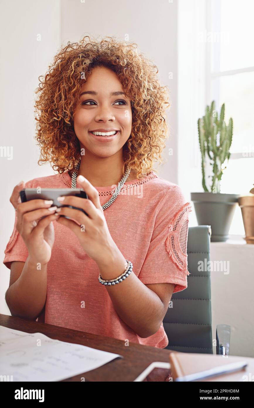 You have to think big. a designer using her cellphone at the office. Stock Photo