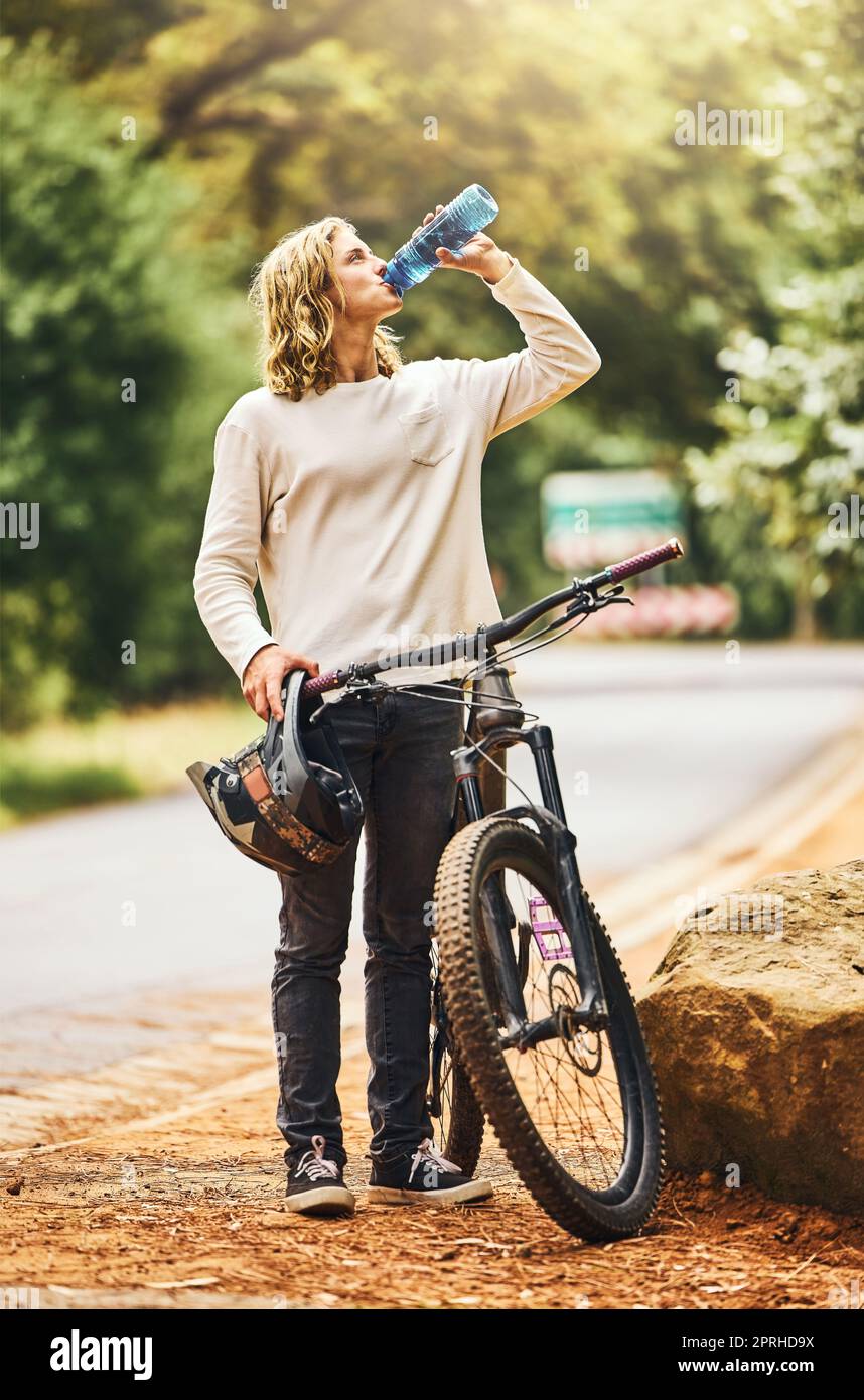 Health, cycling and woman drinking water on a break in nature to
