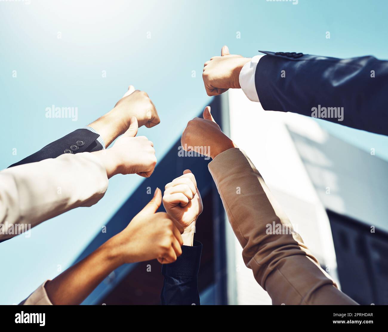 We believe in doing things together. a group of businesspeople showing a thumbs up gesture. Stock Photo