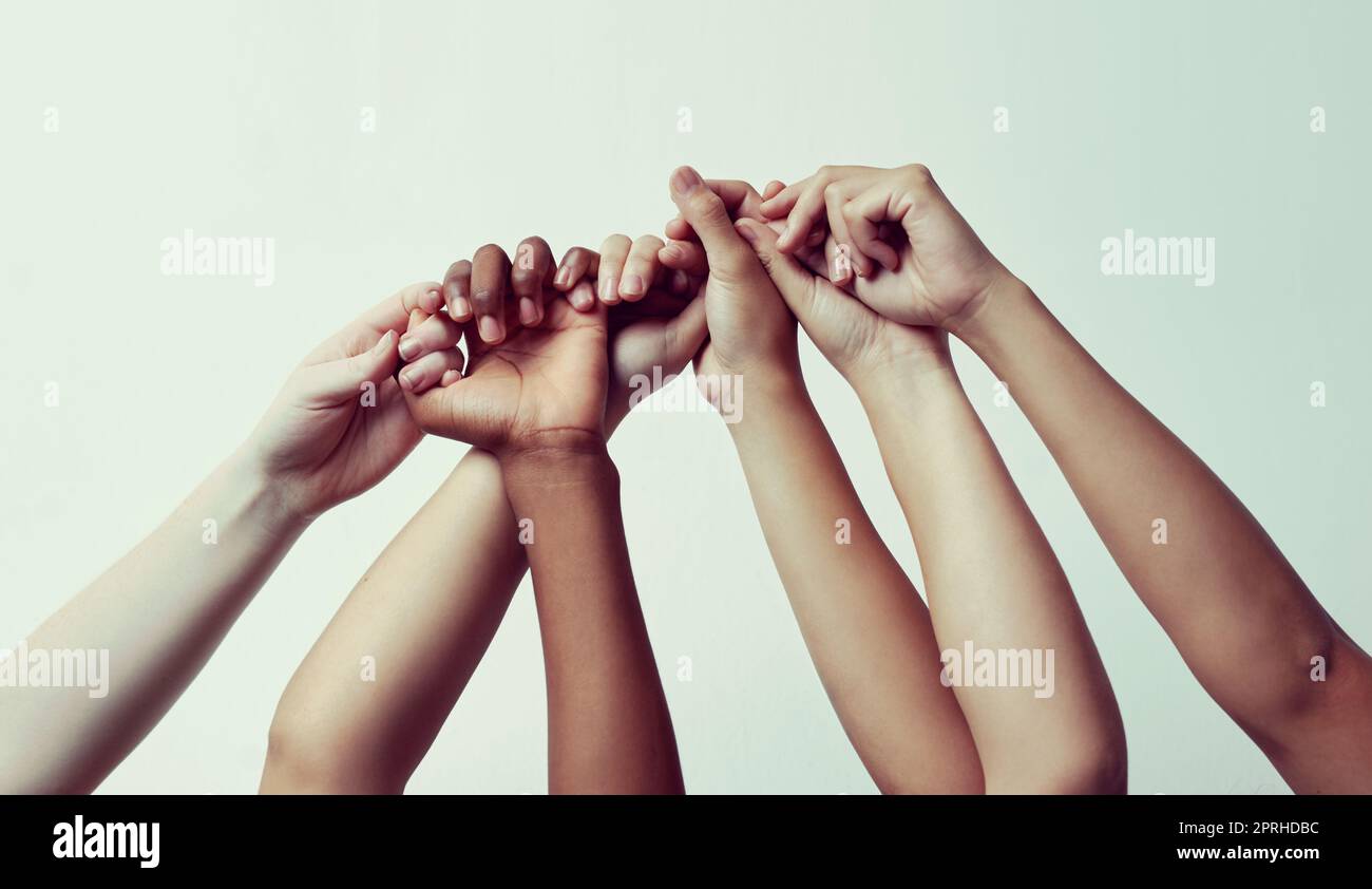 True support. a group of people holding each others thumbs with their hands raised. Stock Photo