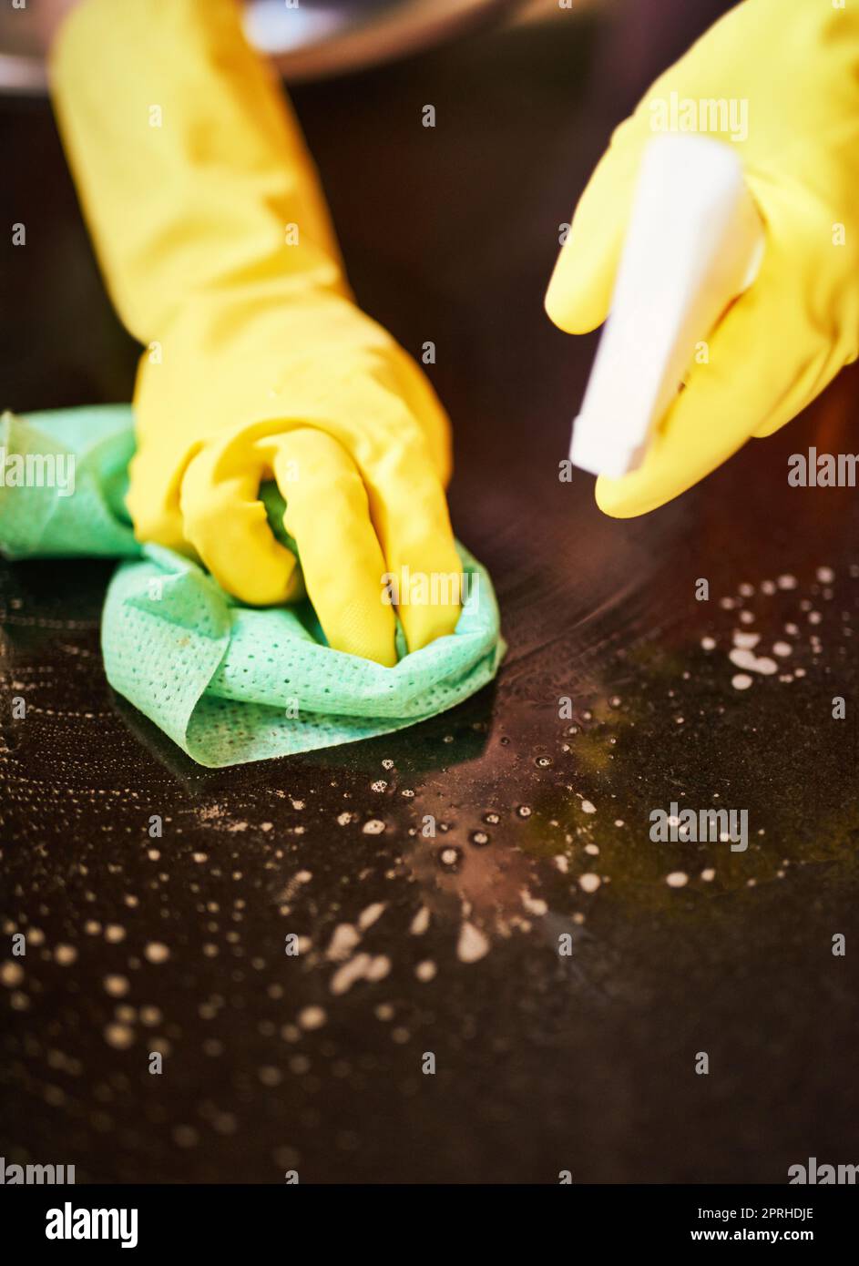 Spraying and scrubbing to a spotless surface. Closeup shot of a person cleaning a kitchen surface. Stock Photo