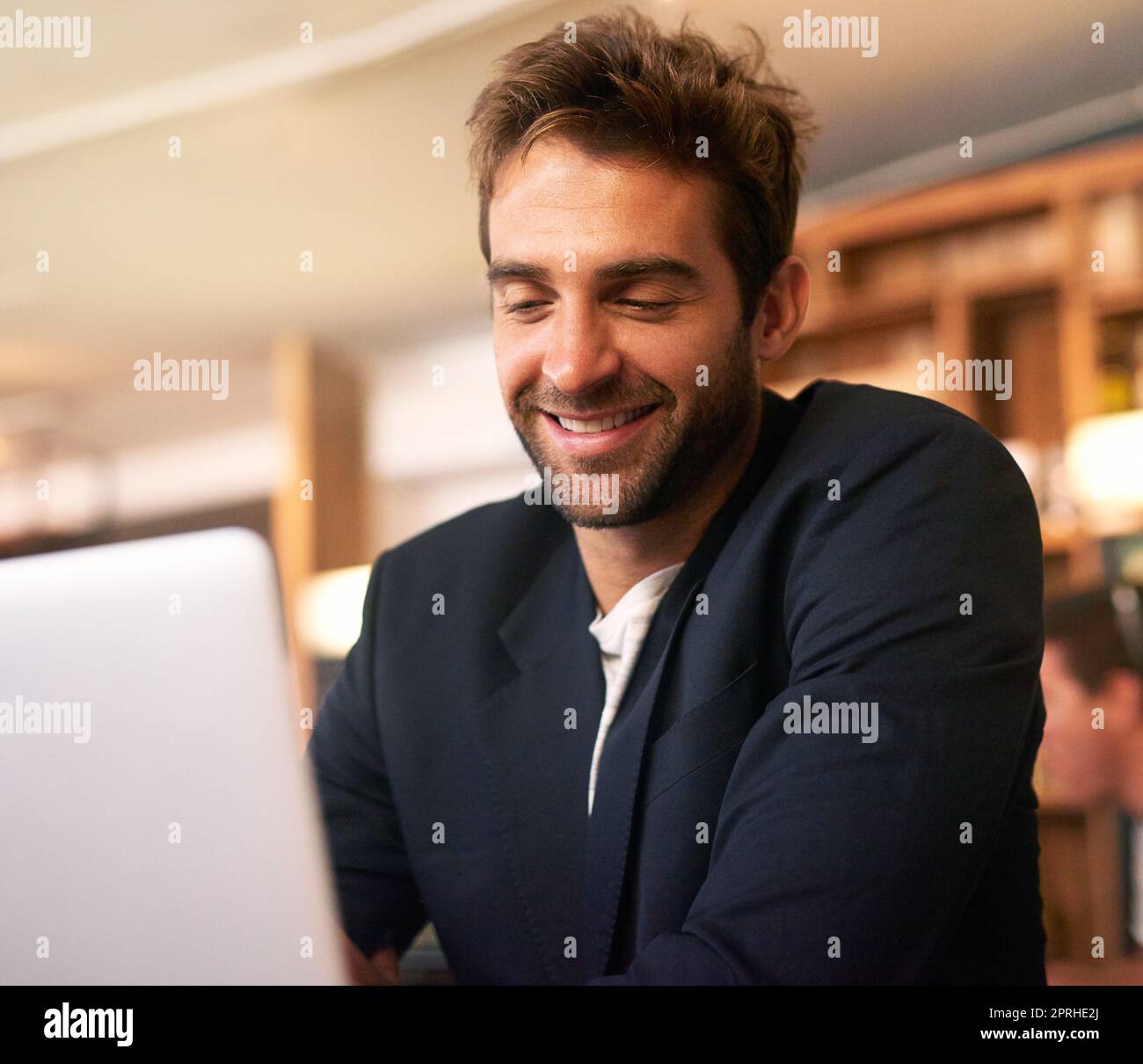 Business at leisure. a handsome young man sitting with a laptop in a cafe. Stock Photo