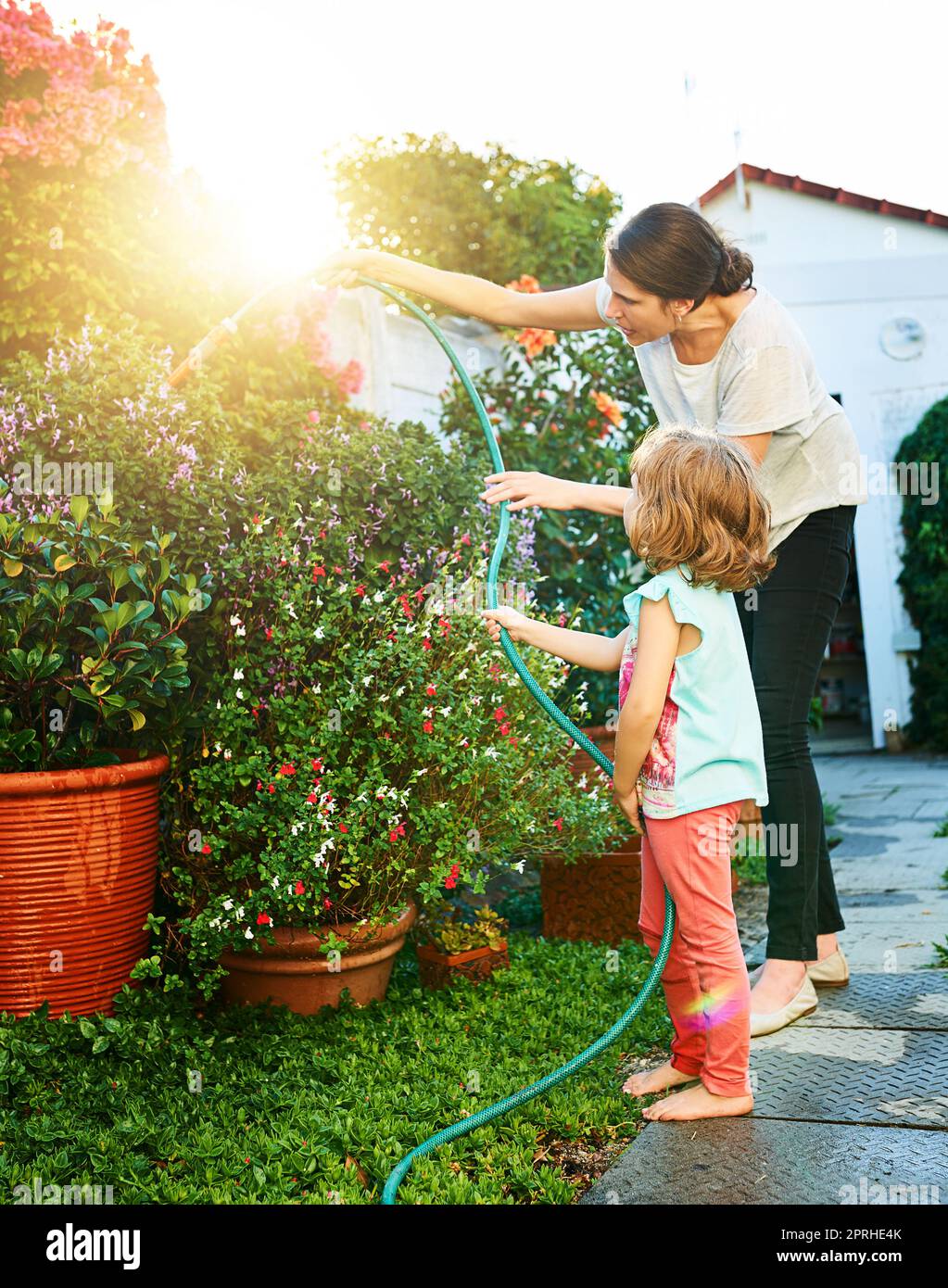 Taking care of the garden is her job now. a mother and daughter doing