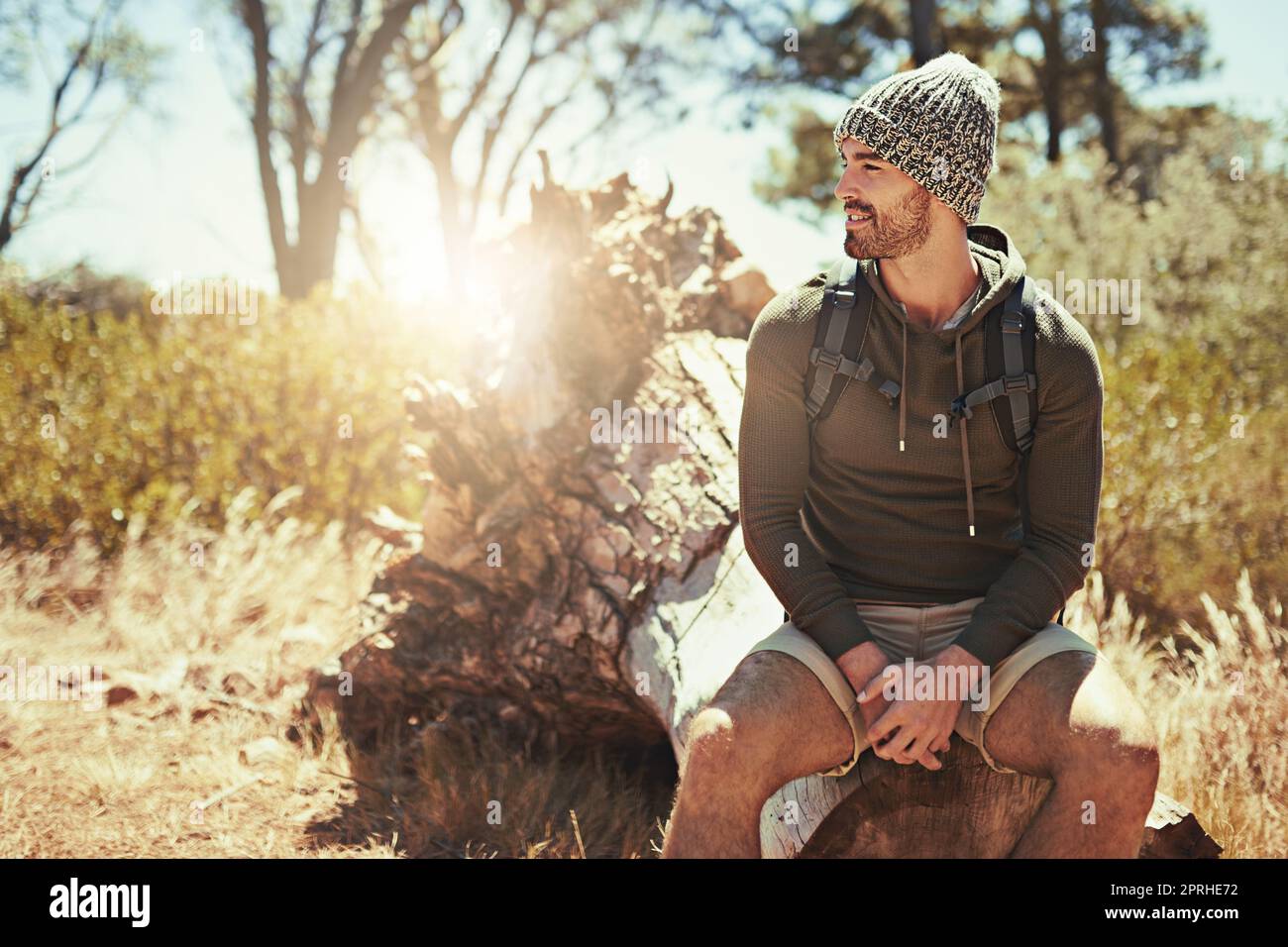 He loves being out here. a young man taking a break while hiking. Stock Photo