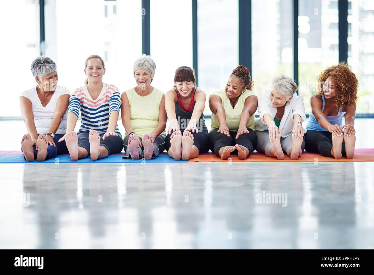 Its important to warmup. a group of women warming up indoors. Stock Photo